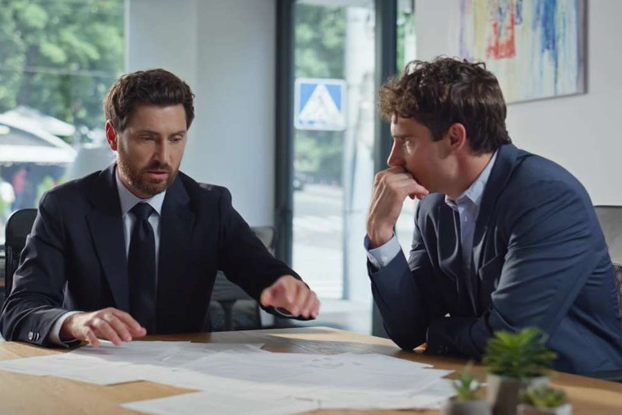 Dos profesionales negocian un acuerdo en una mesa de reuniones